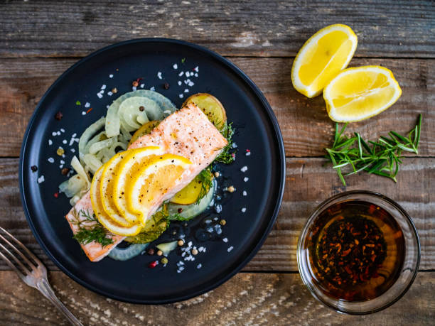 istock Roasted salmon steak served with lemon and onion on wooden table 1264421287