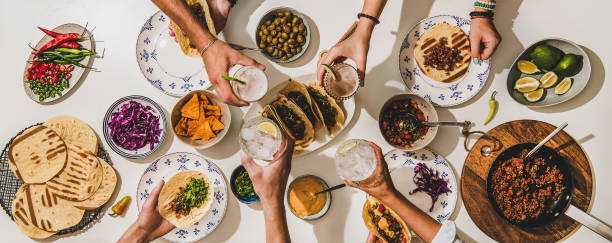 istock Friends feasting at Mexican style Taco party with beer 1264423767