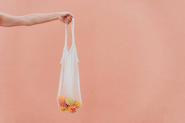 mulher segurando saco de algodão com frutas. conceito de lixo ecológico e zero - earth cheerful orange white - fotografias e filmes do acervo