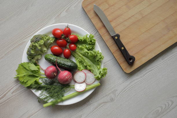 istock Fresh vegetables in a white plate on a light wooden table 1264430001
