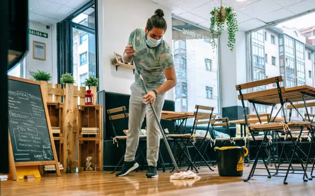 Photo of Worker mopping the floor of a restaurant