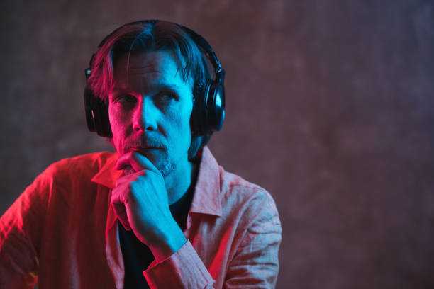 istock Adult stylish man with colored lighting on dark background. 1264431630