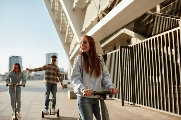 jazda klimaty. grupa przyjaciół korzystających z hulajnóg i segwayów w słoneczny dzień - sunny cheerful close up outdoors zdjęcia i obrazy z banku zdjęć