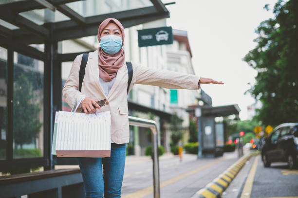 istock Young Asian Muslim female hailing a cab 1264432673