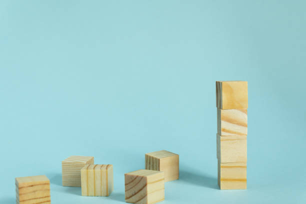 istock Construction of wooden cubes on blue background with copy space. Mockup composition for design 1264437924