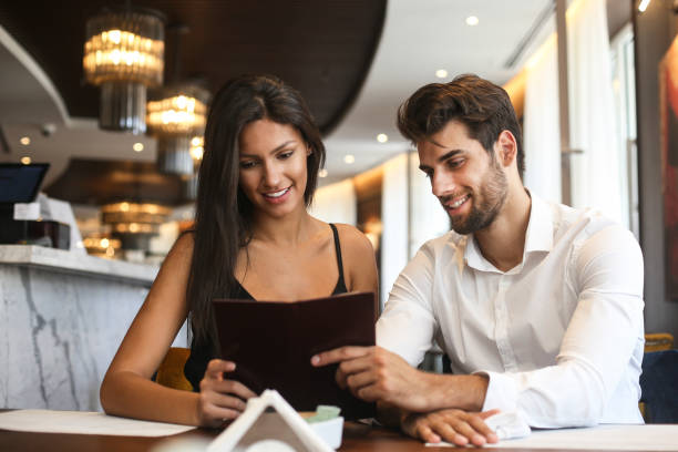 istock Young couple reading a menu in a restaurant 1264439758