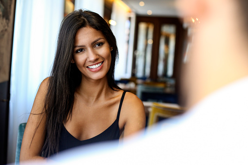 Young couple in a restaurant. Both about 25 years old, Caucasian and Latin people.