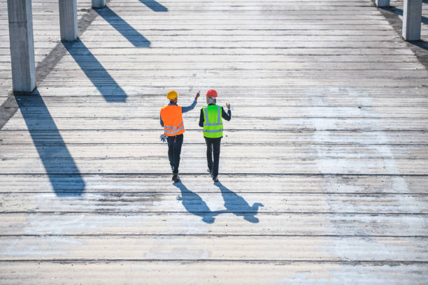 Foreman and Manager Walking Length of Construction Site