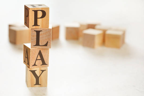 istock Four wooden cubes arranged in stack with word PLAY on them, space for text / image at down right corner 1264441320