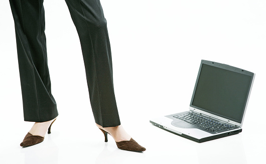 Businesswoman standing beside a laptop