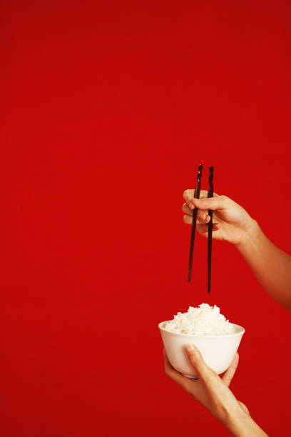 Chopsticks on a blue napkin next to a white empty rice bowl