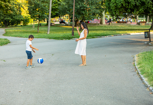 Asian mother and son Playing Soccer In Park Together. Image of family, mother and son playing ball in the park.