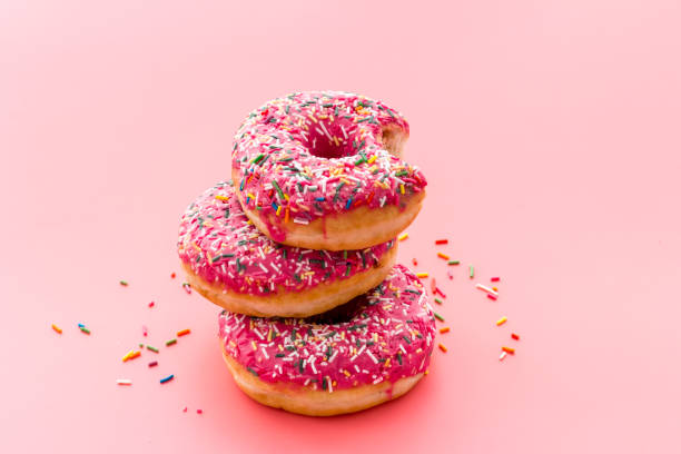 istock Pink berry donuts close up. Glazed and sprinkles bakery 1264457636