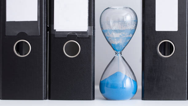 istock Expired hourglass stands between file folders 1264458613