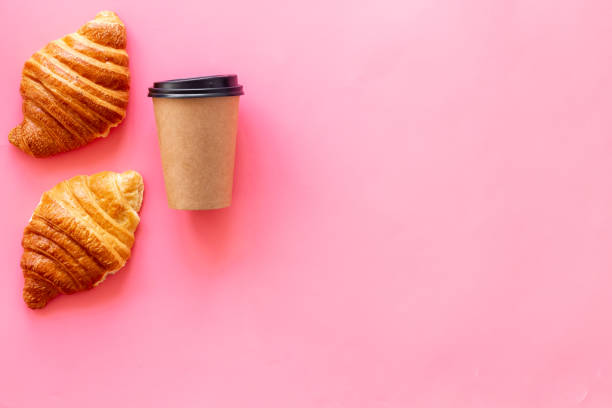 istock Coffee and croissants on pink background top view 1264459116