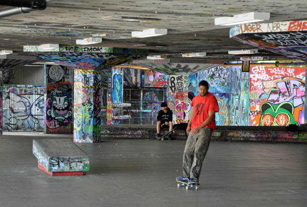 öffentlicheskateboard / bmx park mit skatern. unter der royal festival hall, london southbank. - skateboard park ramp skateboard graffiti stock-fotos und bilder