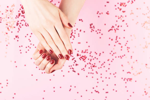 istock Two woman hands and falling confetti on pink background. 1264462944