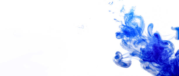 istock Blue ink injected into water from syringe, colour mixing with water creating abstract shapes, banner with space for text left side 1264469439