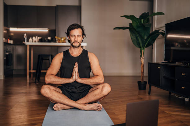 istock Young man meditating in the living room 1264470193