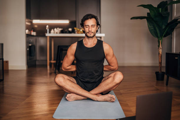 istock One young man meditating in the living room 1264470602
