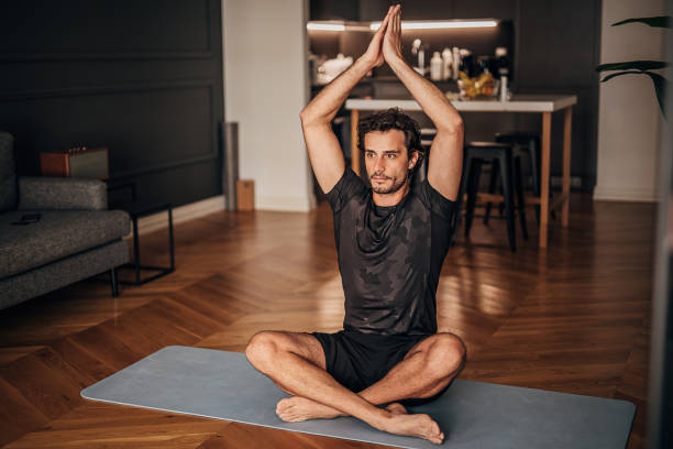 istock One young man doing yoga on exercise mat at home 1264470666