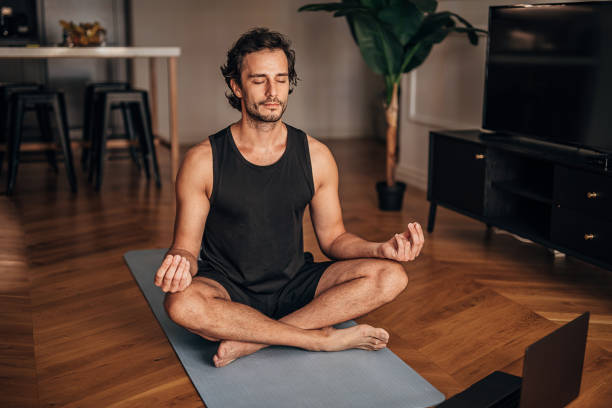 istock Handsome man meditating in the living room 1264471969