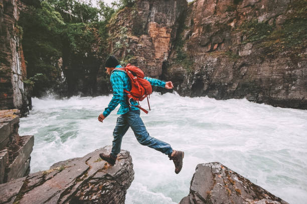 Running man travel adventure active vacations healthy lifestyle endurance extreme sport concept backpacker jumping on cliff above canyon river Running man travel adventure active vacations healthy lifestyle endurance extreme sport concept backpacker jumping on cliff above canyon river norrbotten province stock pictures, royalty-free photos & images