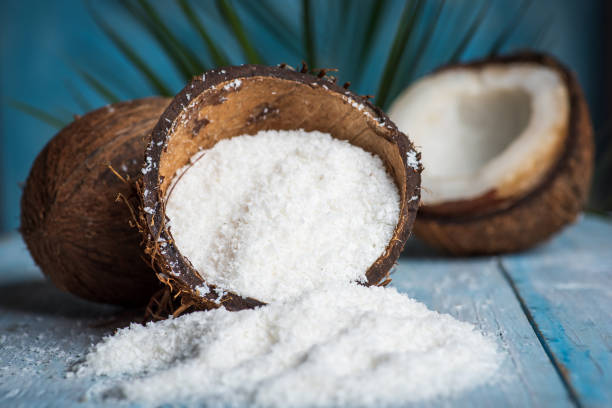 тертый кокосовый порошок, выпадающих из скорлупы - powdered coconut стоковые фото и изображения