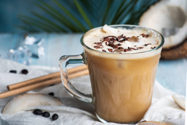 Coconut milk latte coffee decorated with grated chocolate Coconut milk latte coffee decorated with grated chocolate in a modern glass cup closeup coconut milk stock pictures, royalty-free photos & images