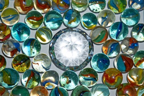 istock Yellow, green, blue and red glass marbles on a table. 1264475419
