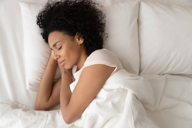 istock African American woman with hands under cheek sleeping in bed 1264479208