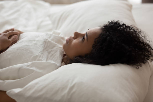 istock African American woman with open eyes lying in bed 1264479212