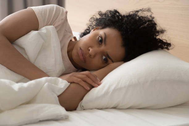 istock Unhappy African American woman suffering from insomnia, lying in bed 1264479214