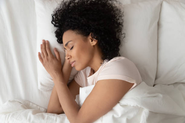 istock Beautiful African American woman sleeping in comfortable bed top view 1264479215
