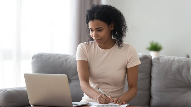 istock Focused African American woman using laptop, making notes 1264479283