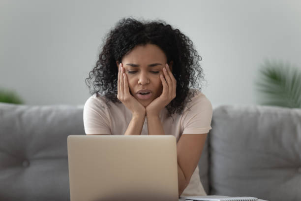 istock Lazy bored African American woman using laptop, doing routine work 1264479296