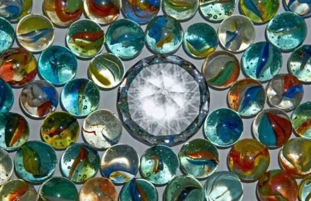 istock Yellow, green, blue and red glass marbles on a table. 1264479439