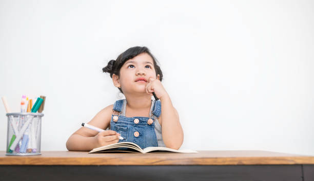 porträt von kleinen niedlichen asiatischen mädchen halten bleistift schreiben in notizbuch. spaß lernen durch dies betätigen aktivität kleinkind frühkindliche bildung hausaufgaben schule konzept banner - child asian ethnicity little girls toddler stock-fotos und bilder