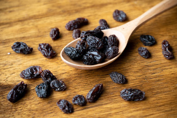 istock dried raisins on wooden spoon. Selective focus on some raisins. 1264482221