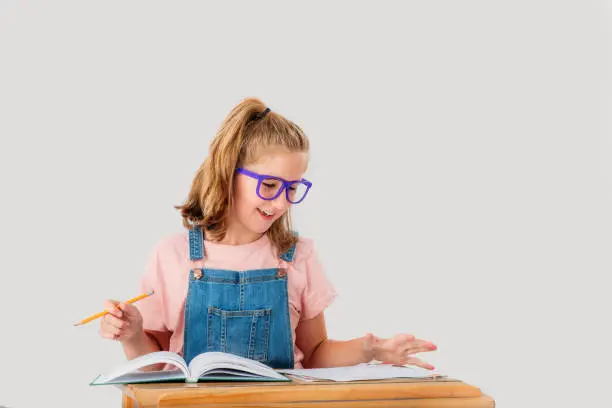 Photo of A smiling nine year old student is working at her school desk.