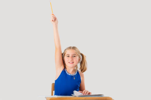 istock A nine year old student has a hand raised to ask or to answer a question while seating at her school desk. 1264484982