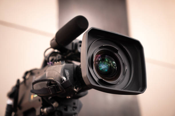 Television camera lens, Film of Video movie recording films shooting of grand opening in conference hall Live streming for presentation with bokeh light background. Media Production Concept stock photo