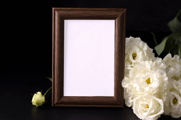 istock mockup of empty mourning frame next to white flowers. death and sorrow concept 1264486753