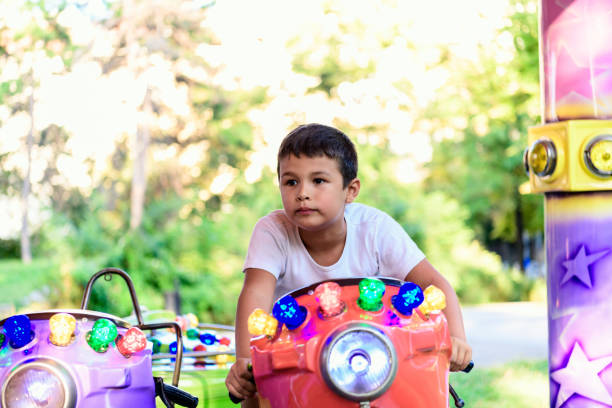 Young boy riding a toy car isolated on white background