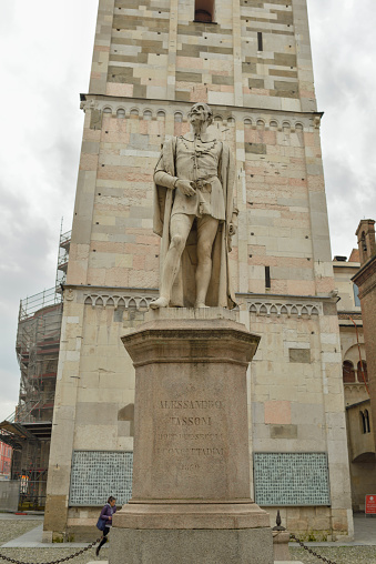 Modena, Emilia-Romagna, Italy - February 08, 2014: General view of the Alessandro Tassoni monument in front of the Ghirlandina