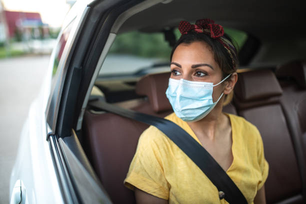 istock Woman with protective face mask, looking through the window and enjoying a ride 1264500790
