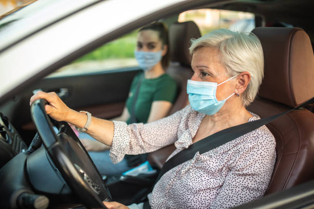 istock Senior woman with protective mask driving ride sharing car 1264500994