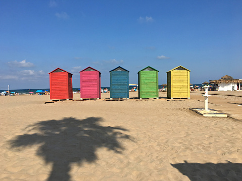 Valencia, Spain - August 2, 2020: Five wooden watercloset booths at the beach for public use. The city government install them as a free service to the people that visit the beach