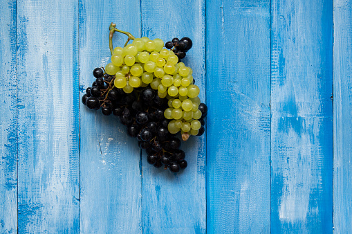 White and red grapes on wood