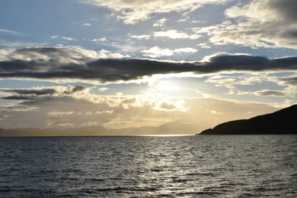 Sky, sea and mountains meeting point Sunlight coming behind the clouds over sea and cliffs applecross peninsula stock pictures, royalty-free photos & images